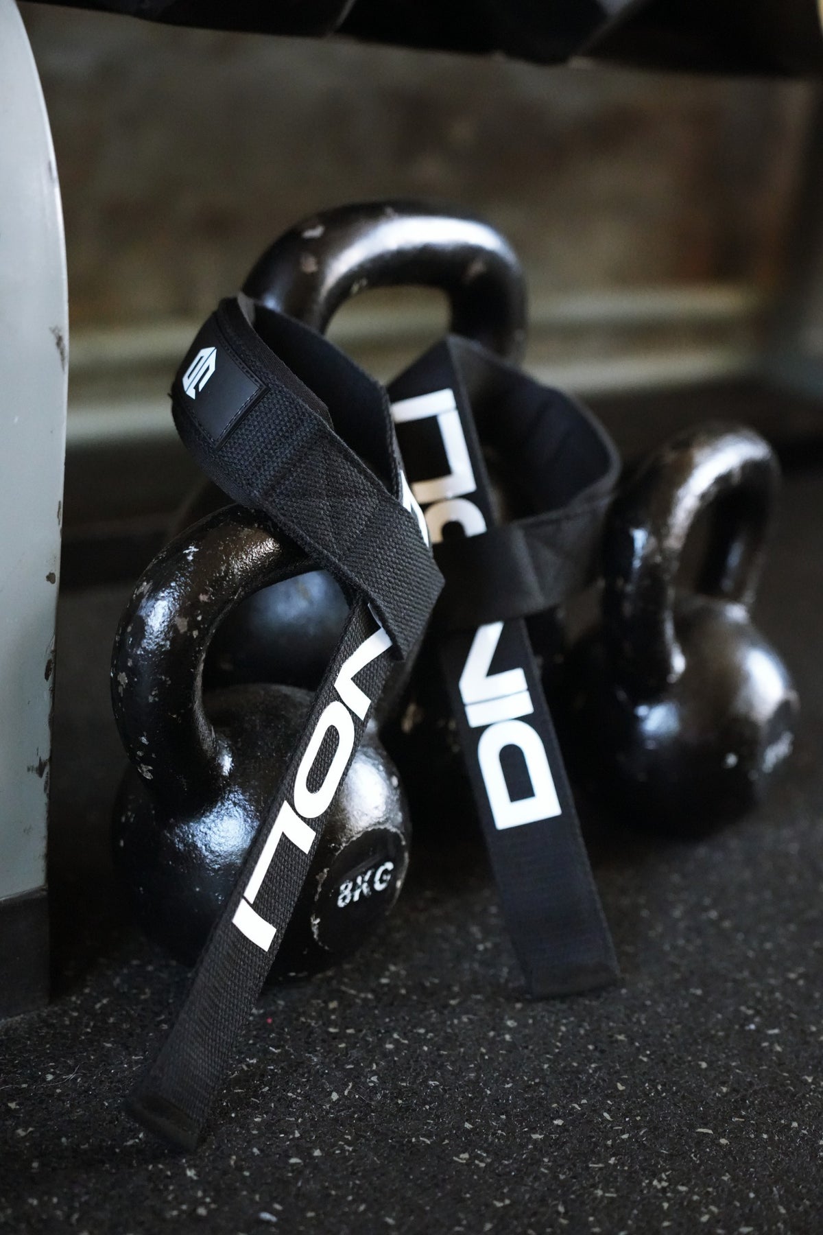 DINOLI Auto-Lock Lifting Straps displayed with kettlebells