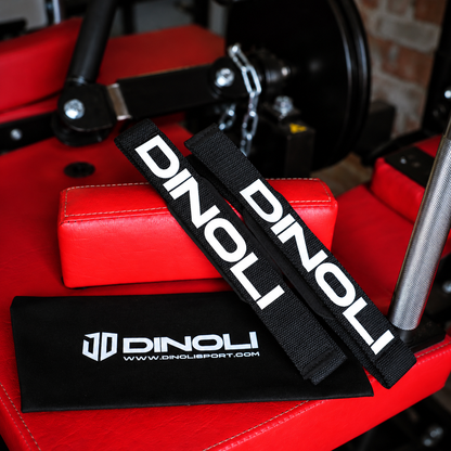 DINOLI black auto-lock lifting straps with white branding and matching storage pouch displayed on a red gym bench.