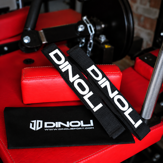 DINOLI black auto-lock lifting straps with white branding and matching storage pouch displayed on a red gym bench.