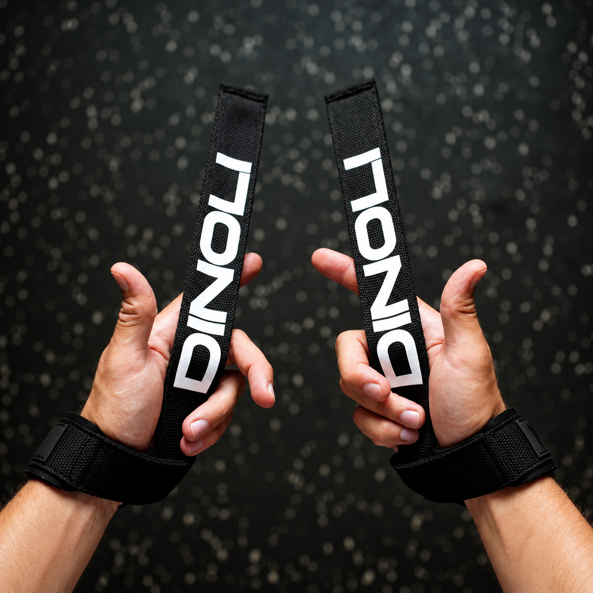 Black DINOLI auto-lock lifting straps worn around both wrists, showing the white DINOLI branding and adjustable wrist cuffs.